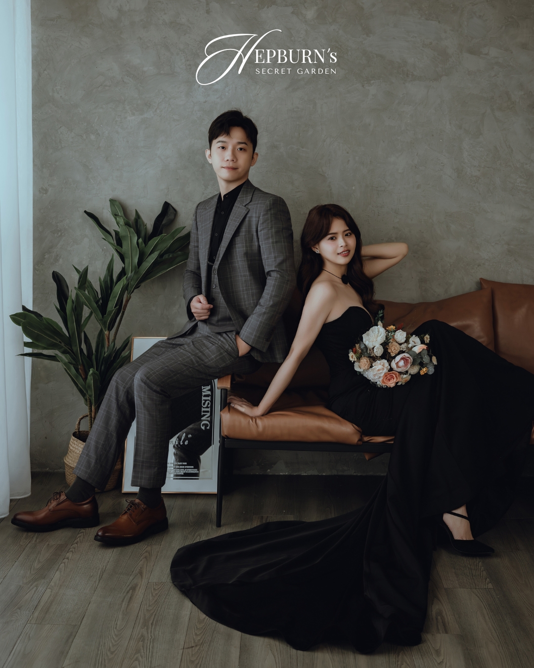 新人坐在皮沙發展現格紋婚紗西裝的垂墜感
